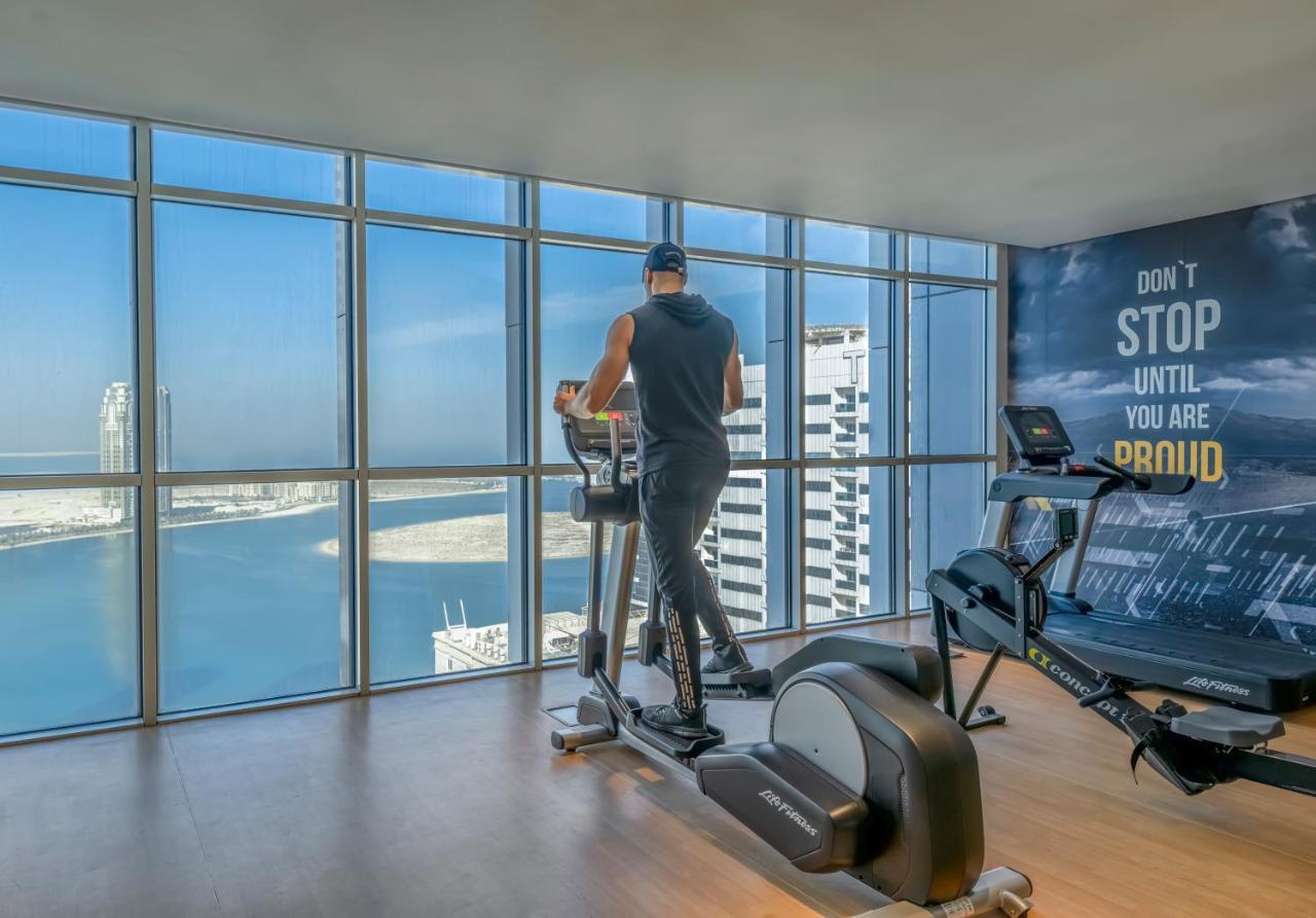 Pullman Sharjah Hotel Bagian luar foto A man using a cross trainer